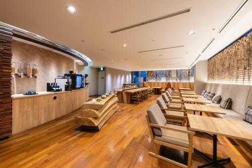 a restaurant with wooden tables and chairs and a bar at Hotel Gracery Sapporo in Sapporo
