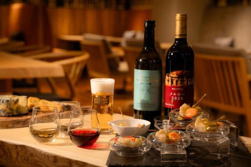 a table with glasses of wine and wine bottles at Hotel Gracery Sapporo in Sapporo