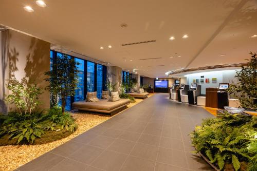 an office lobby with plants and couches at Hotel Gracery Sapporo in Sapporo