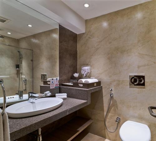 a bathroom with a sink and a shower at Hotel Swosti Premium Bhubaneswar in Bhubaneshwar