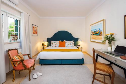 a bedroom with a bed and a desk with a laptop at Villa Tranberg Suites in Ferreiras