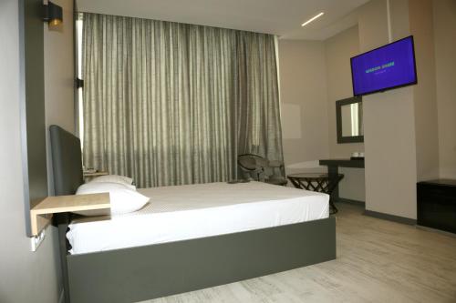 a hotel room with a bed and a flat screen tv at zoom hotels in Eskiömerler