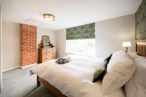 a bedroom with a large bed and a window at 1 Lavender Cottages, Knodishall in Saxmundham