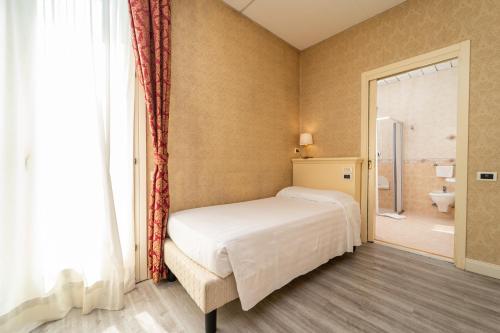 een slaapkamer met een bed en een douche en een badkamer bij Hotel Terme Roma in Abano Terme
