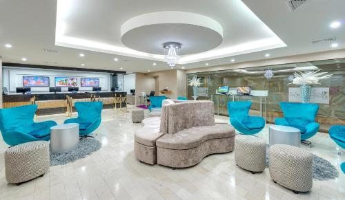 a lobby with blue chairs and a waiting room at Hotel Cartagena Plaza in Cartagena de Indias