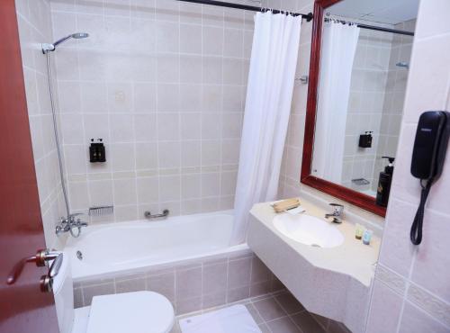 a bathroom with a sink and a toilet and a shower at Icon Hotel Apartments in Dubai