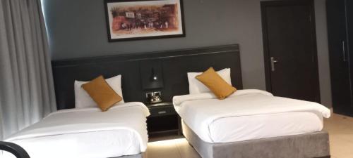 a hotel room with two beds and a table at O Beach Hotel & Resort in Sowayma