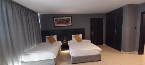 two beds in a hotel room with two beds sidx sidx sidx at O Beach Hotel & Resort in Sowayma