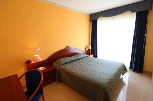 a hotel room with a bed and a window at Hotel APAN in Reggio di Calabria