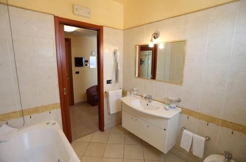a bathroom with a tub and a sink and a bath tub at Hotel APAN in Reggio di Calabria