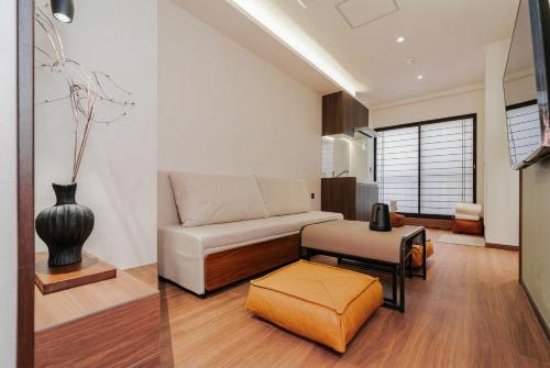 a living room with a couch and a stool at 北川秋叶原 羽田机场直达 秋叶原站步行4分钟和风民宿 适合家庭和情侣入住 Poka Stay Akihabara in Tokyo