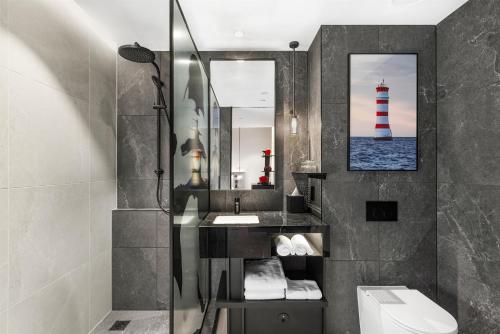 a bathroom with a sink and a mirror and a lighthouse at Radisson RED Auckland in Auckland