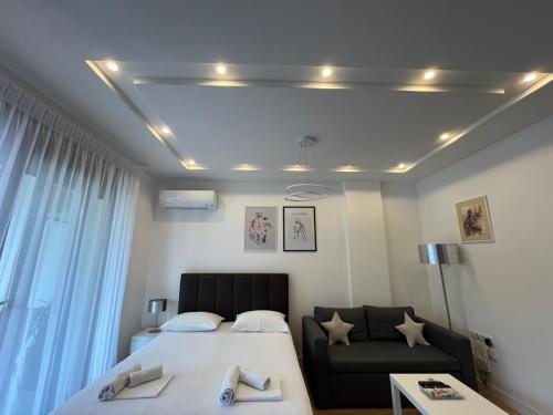 a bedroom with a bed and a couch at Apartman PORTO in Trebinje