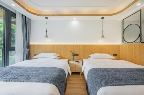 two beds in a room with two mirrors at 安吉季意民宿 Jiyi Boutique Homestay, Anji, Huzhou in Anji