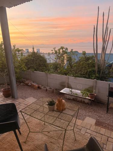 a patio with a table and chairs on a balcony at Memento Vivere in Mossel Bay