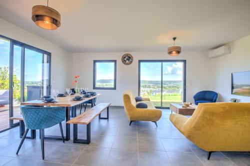 un soggiorno con tavolo da pranzo e sedie di Sunset villa a Trélissac