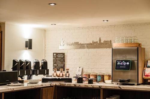 a kitchen with a counter top with a refrigerator at De oude gevangenis Almelo in Almelo