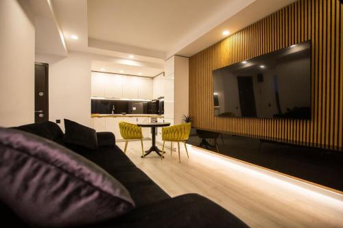 a living room with a couch and a table at Klaus Luxury Apartment #Bucharest in Ştefăneştii de Sus