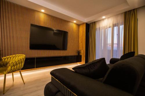 a living room with a couch and a flat screen tv at Klaus Luxury Apartment #Bucharest in Ştefăneştii de Sus