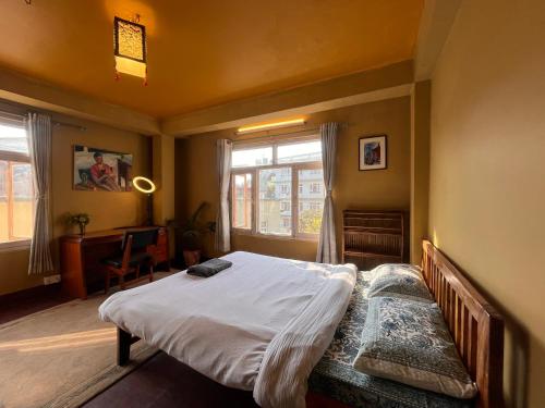 a bedroom with a large bed and a window at Sunny Side Up top-floor apartment in Kathmandu