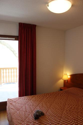 une chambre avec un lit avec un animal en peluche dessus dans l'établissement Résidence Mer & Golf Pic du Midi, à La Mongie