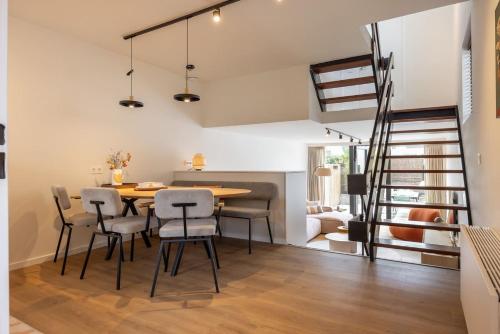 a dining room and living room with a table and chairs at Hello Zeeland - De Brabander Wijk 111 in Cadzand