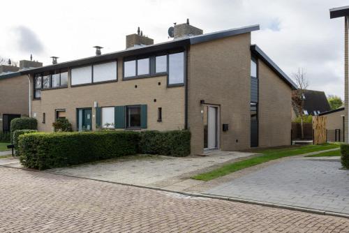 a large brick house on a cobblestone street at Hello Zeeland - De Brabander Wijk 111 in Cadzand