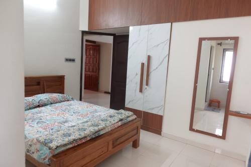 a bedroom with a bed and a large mirror at Thiruveesar Family Retreat near Airport in Tiruchirappalli