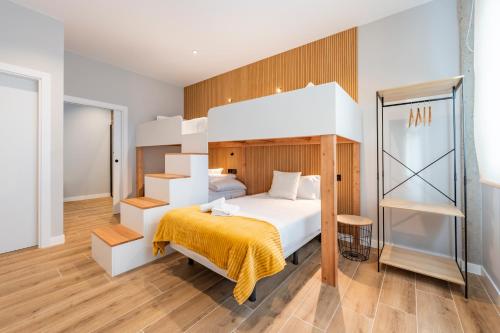 a bedroom with a large bed with a yellow blanket at White Tree Rooms and Apartments in O Pedrouzo