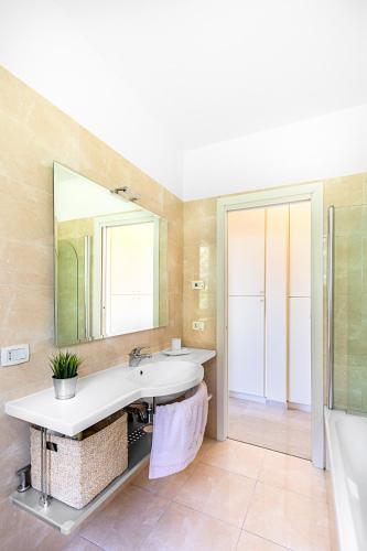 a bathroom with a sink and a mirror and a tub at Villa Perla by Whale Homes in Lonato