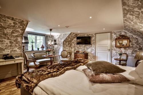 een slaapkamer met een groot bed in een kamer met stenen muren bij Vadstena Klosterhotell Konferens & Spa in Vadstena