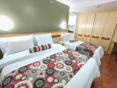 a hotel room with two beds with red and grey blankets at RARIDADE!!! - Flat Particular de Alto Padrão - Limpeza Diária Gratuita - Excelente Atendimento - Ótimo Preço - Cama King ou Queen Size - Condomínio do Hotel Lets Idea in Brasília