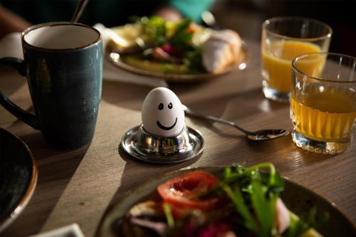ein Tisch mit einem Teller Essen und einem Ei auf einem Tisch in der Unterkunft Scandic Kemi in Kemi