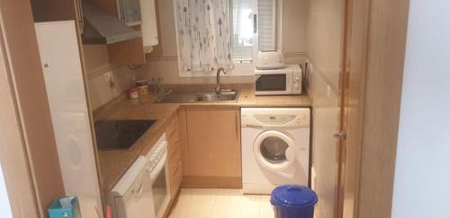 a small kitchen with a sink and a washing machine at Apartamentos Marina d'or in El Borseral