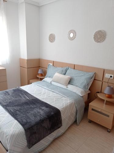a bedroom with a large bed and two tables at Apartamentos Marina d'or in El Borseral