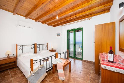 a bedroom with a bed and a table with a bottle of wine at Villa Martha in Ieromónachos