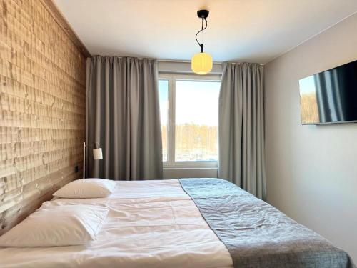 a bedroom with a bed and a window at Ski-Inn Huoneisto in Vuokatti