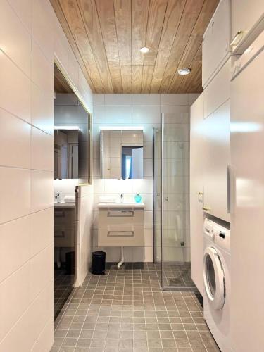 a bathroom with a sink and a washing machine at Ski-Inn Huoneisto in Vuokatti