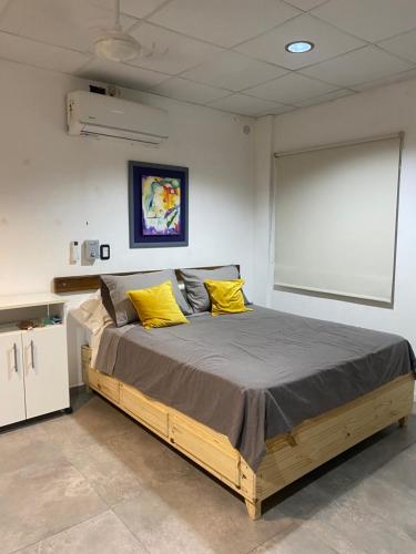 a bedroom with a large bed with yellow pillows at Monoambiente Smart en Corrientes in Corrientes