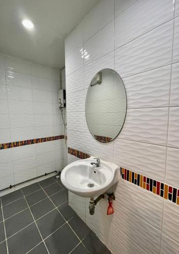 a bathroom with a sink and a mirror at Sampheng Apartment in Bangkok