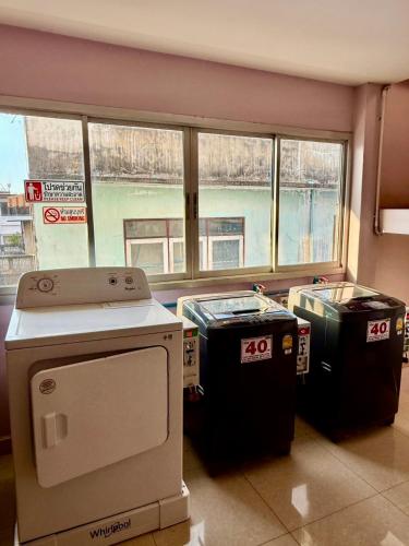 a room with three trash cans in front of a window at Sampheng Apartment in Bangkok
