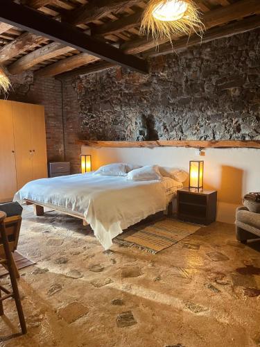 a bedroom with a large bed with two lights on it at Can Masferrer in Riudarenes