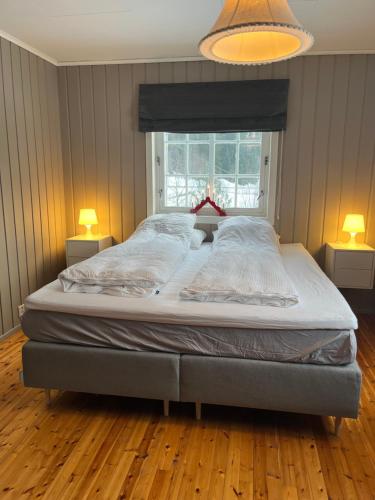 a large bed in a bedroom with two lamps at Bestemorhuset in Øye