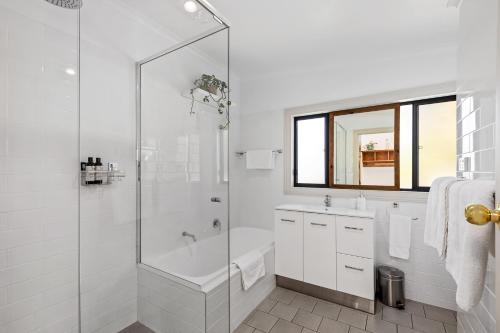 a white bathroom with a tub and a shower at The Other House in Piccadilly