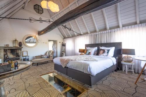 a bedroom with a large bed and a living room at B&B Kasteel Maurick in Vught