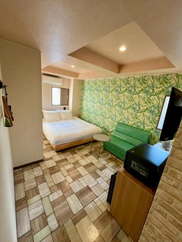 a bedroom with a bed and a couch and a table at Hotel RIO Shinjuku in Tokyo