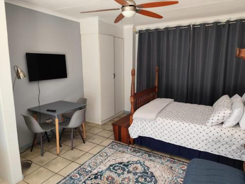 a bedroom with a bed and a table and a television at 899 On Burlington in Pretoria