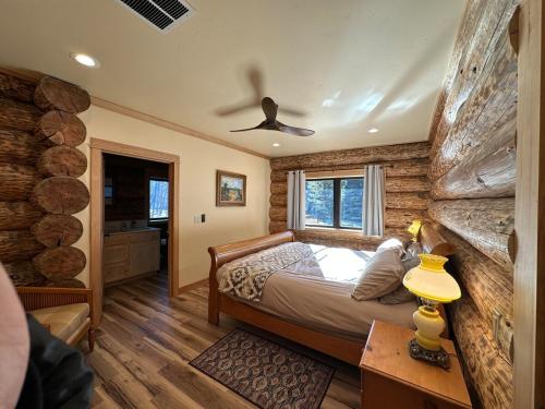 a bedroom with a bed in a room with wooden walls at Waterfront Log Cabin - Sunriver in Bend
