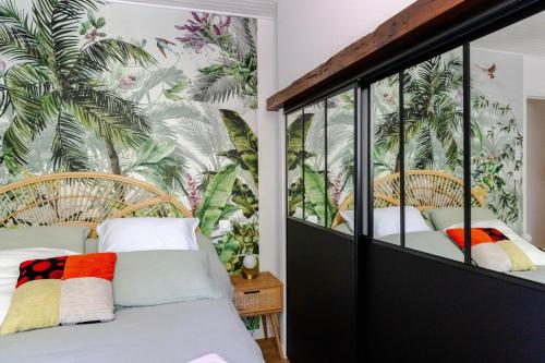 een slaapkamer met 2 bedden en tropisch behang bij Le ruisseau du bejean in Sainte-Gemme