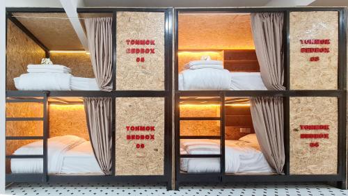 three bunk beds in a room with labels on them at Sleep On The Clouds in Ban Kata